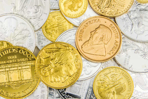 Eine Vielzahl unterschiedlicher Gold- und Silbermünzen ist in diesem Bild abgebildet, die verschiedene Größen und Designs zeigen.